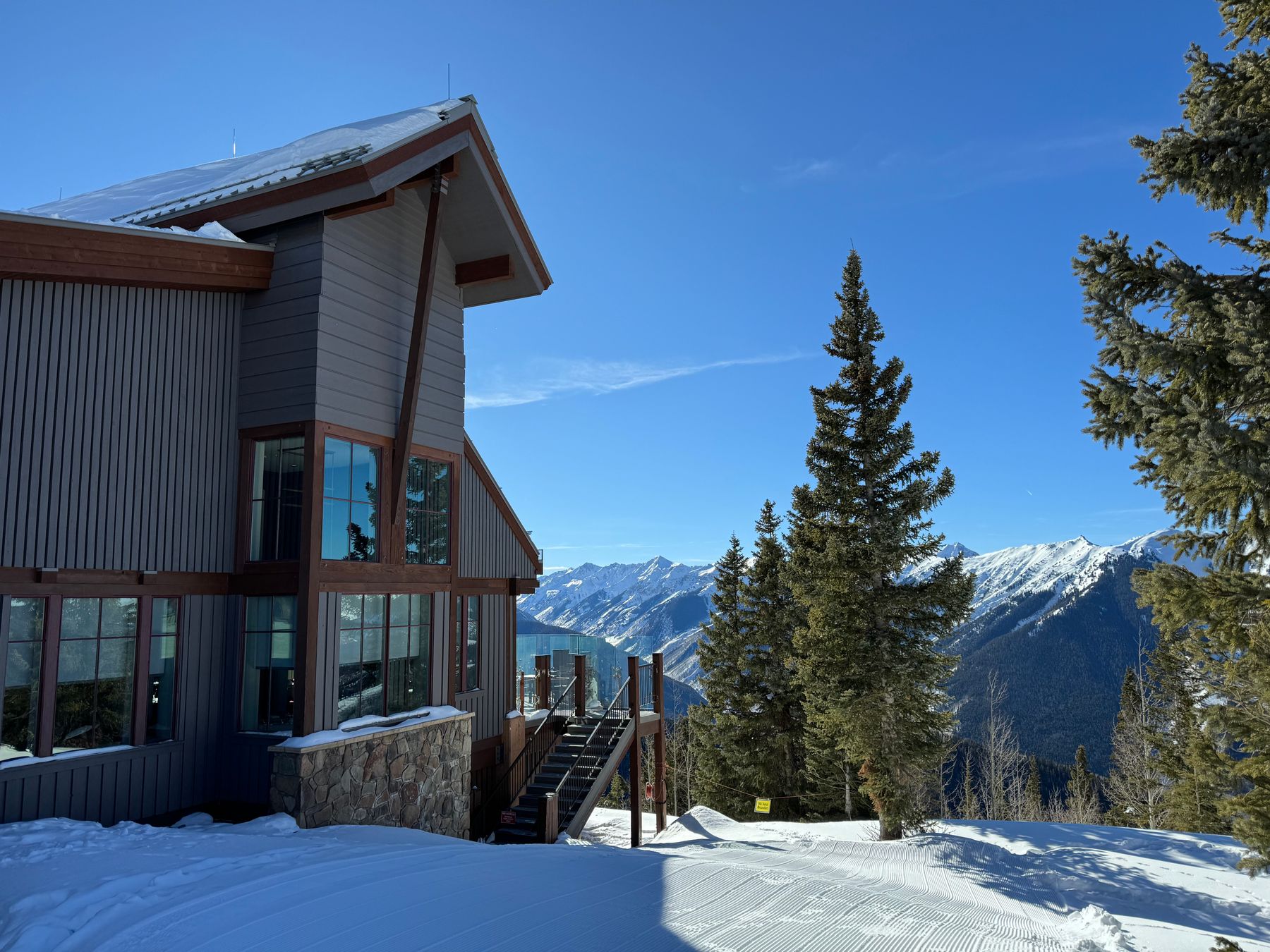 Aspen lodge beneath a snow-covered mountain