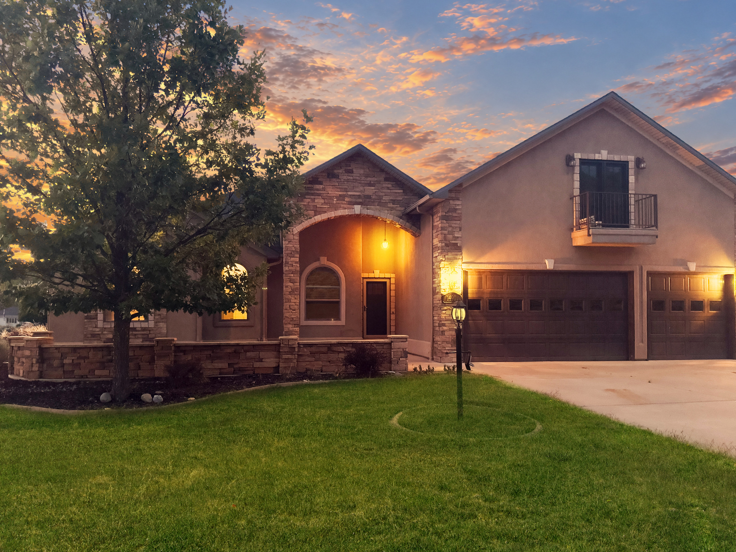 Angled view of a warmly lit entrance and landscaped lawn